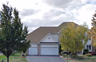 Front view of a residential assisted living facility with two garage doors.