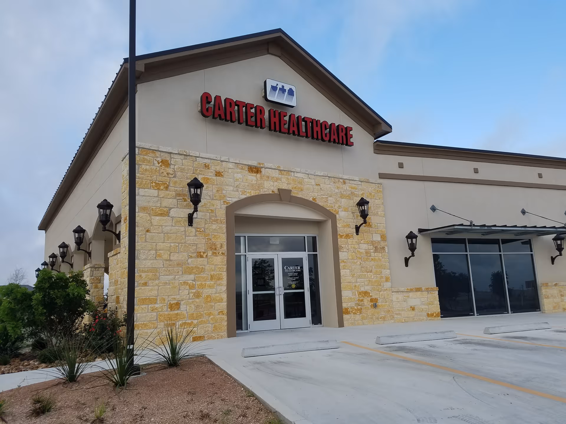Front exterior of Carter Healthcare building with stone facade and glass entrance doors.