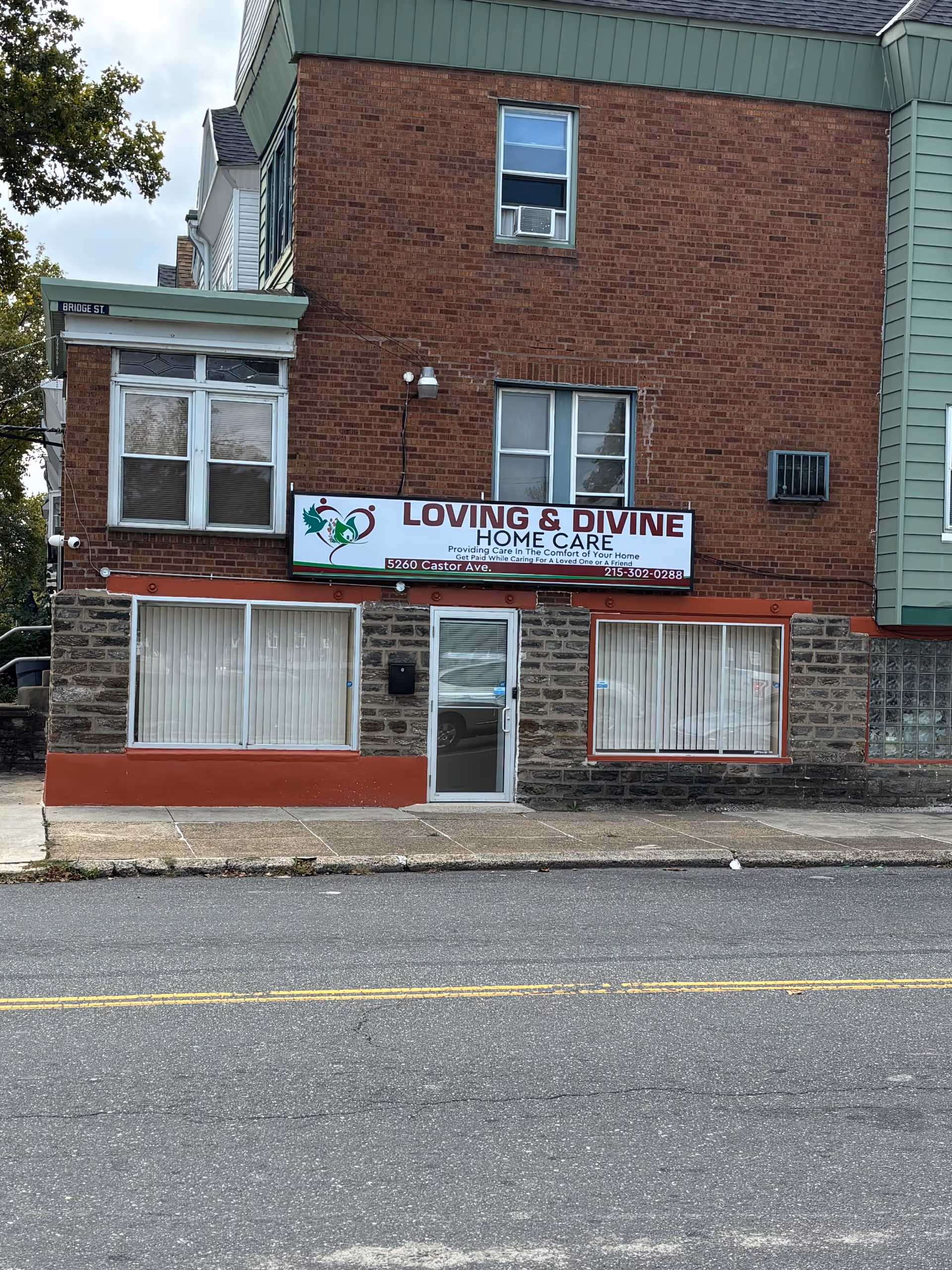 Brick storefront with Loving & Divine Home Care sign and large windows.