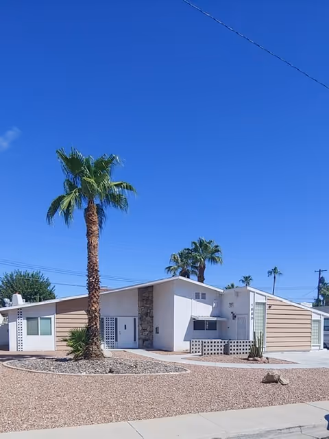 Front exterior of a single-story Las Vegas Group Home with palm trees.