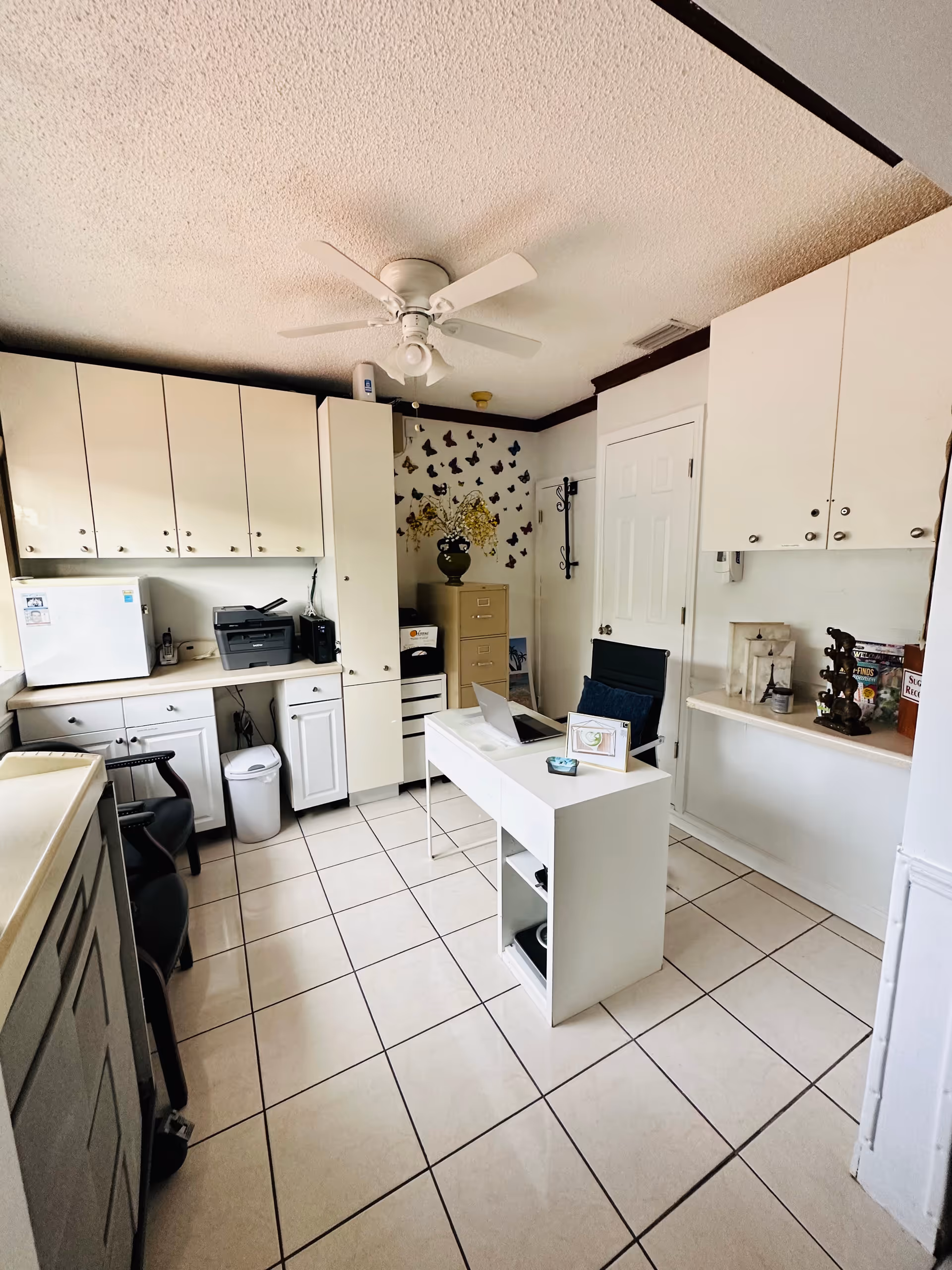 Interior kitchen area with white cabinets, desk, and printer in Paradise Adult Center.