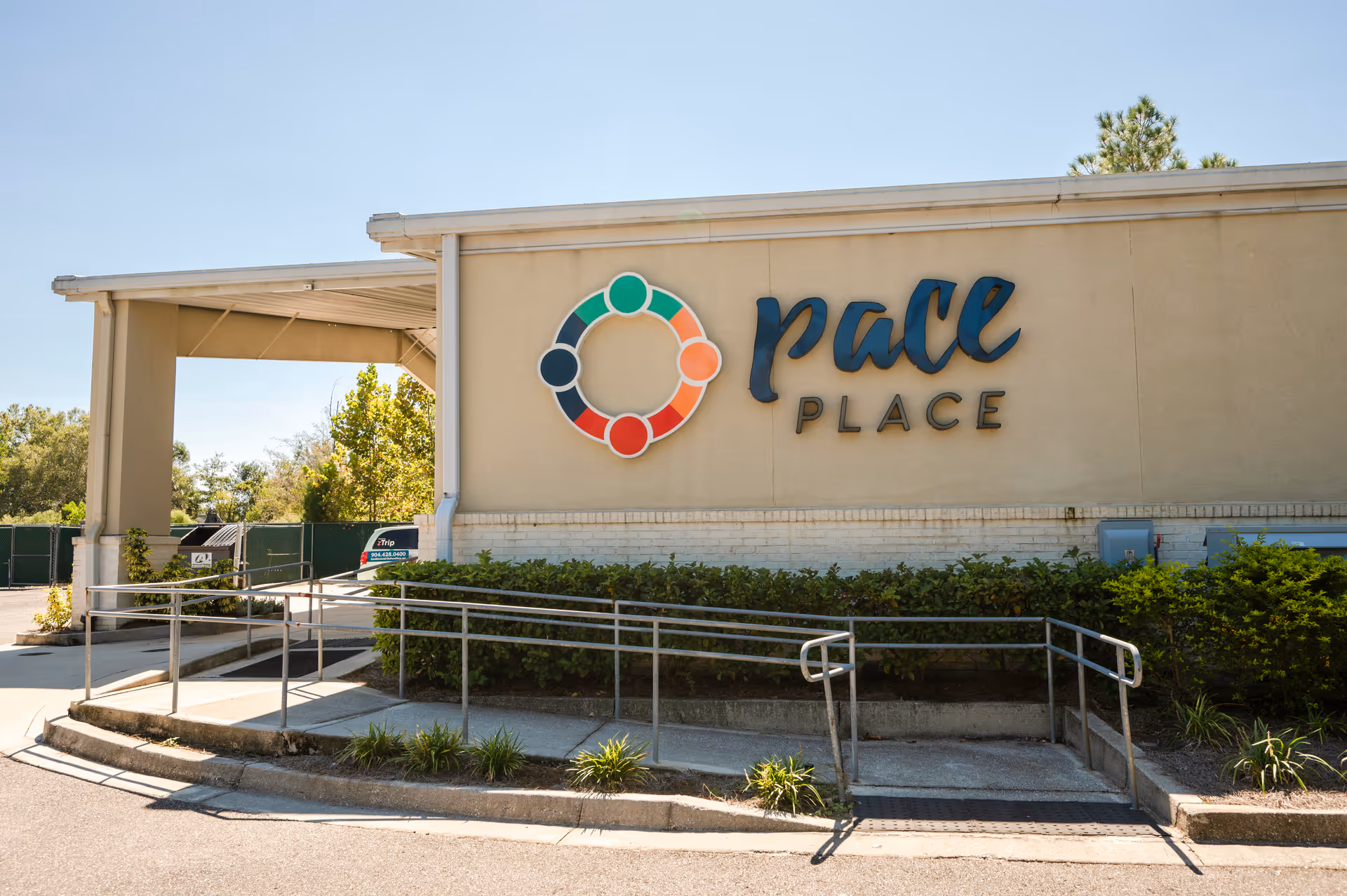 Exterior view of a facility with colorful Pace Place logo on the wall.