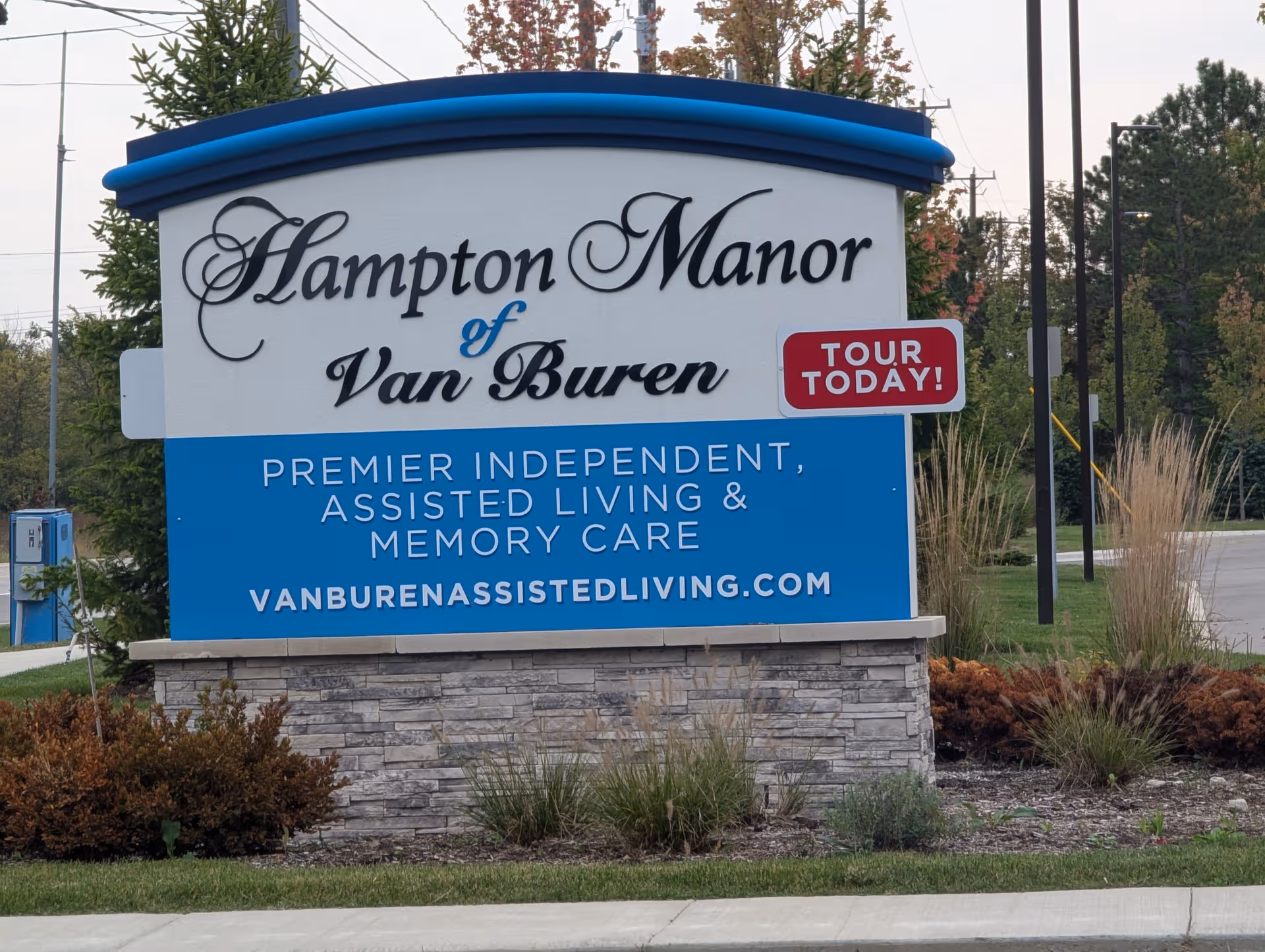 Large exterior sign for Hampton Manor of Van Buren with landscaping.