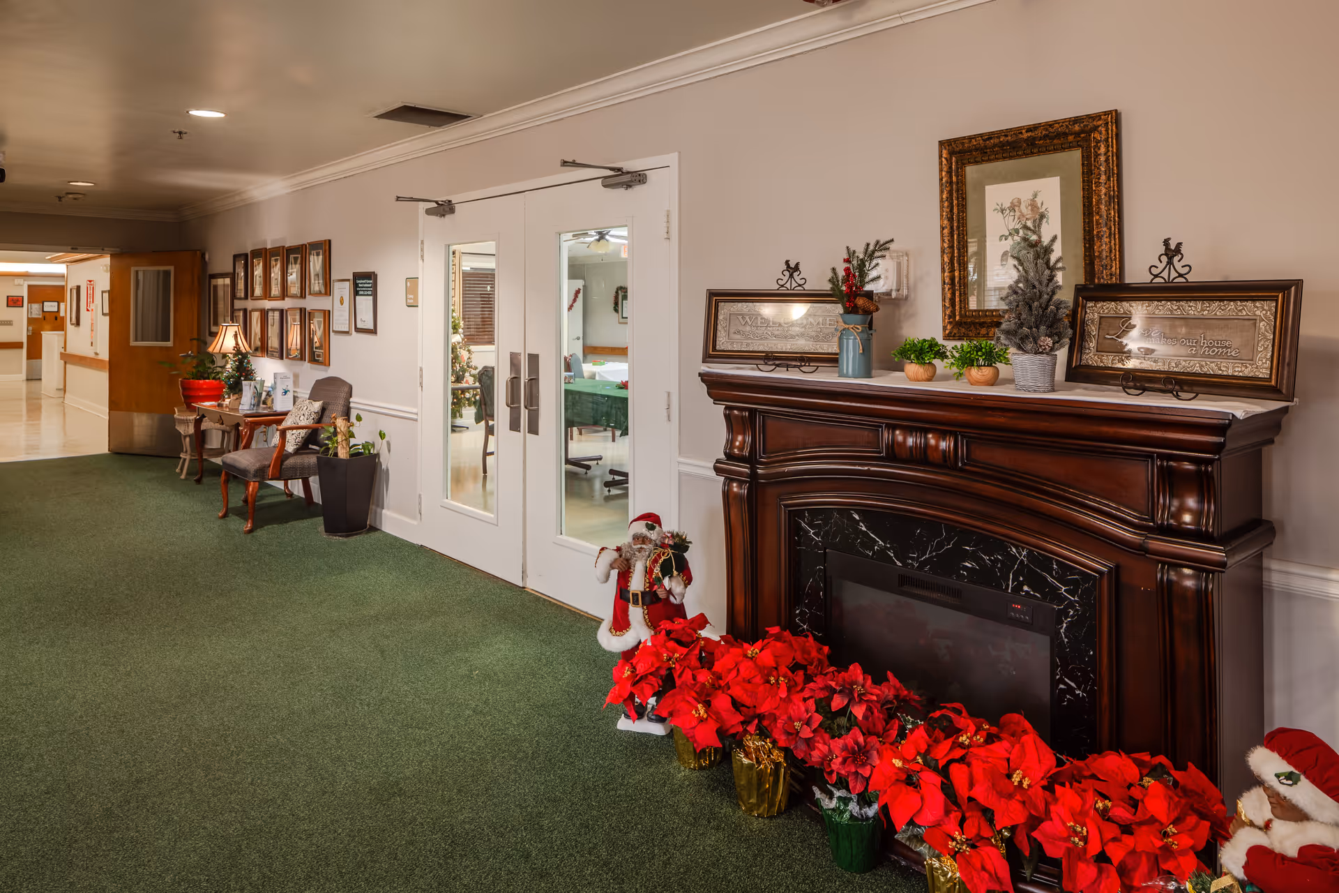 Lobby hallway of a senior living facility with a fireplace and holiday decorations.