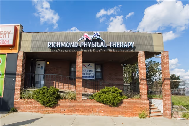 Brick storefront reads Richmond Physical Therapy under a metal awning, with steps and shrubs.