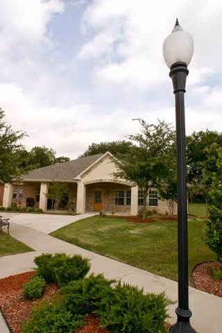 Exterior view of Mustang Creek Estates Allen with entrance, lawn, and street lamp