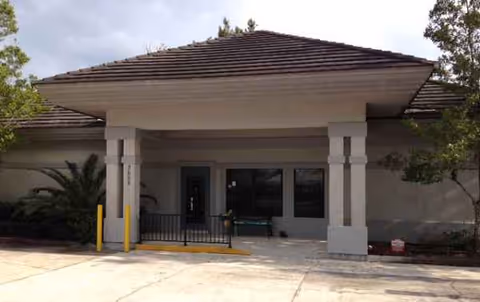 Front entrance of a single-story assisted living facility with a covered porch and columns.