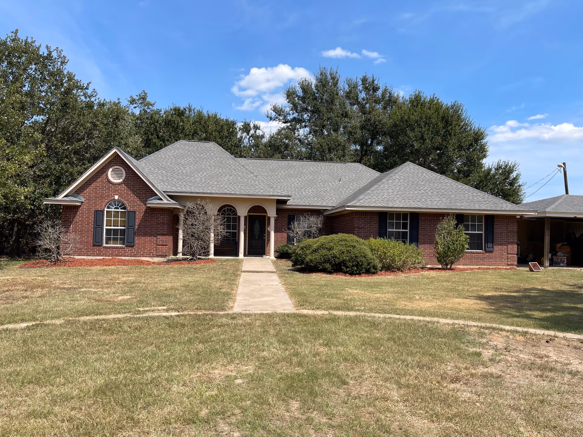 Single story brick senior living building with lawn and walkway to entrance.