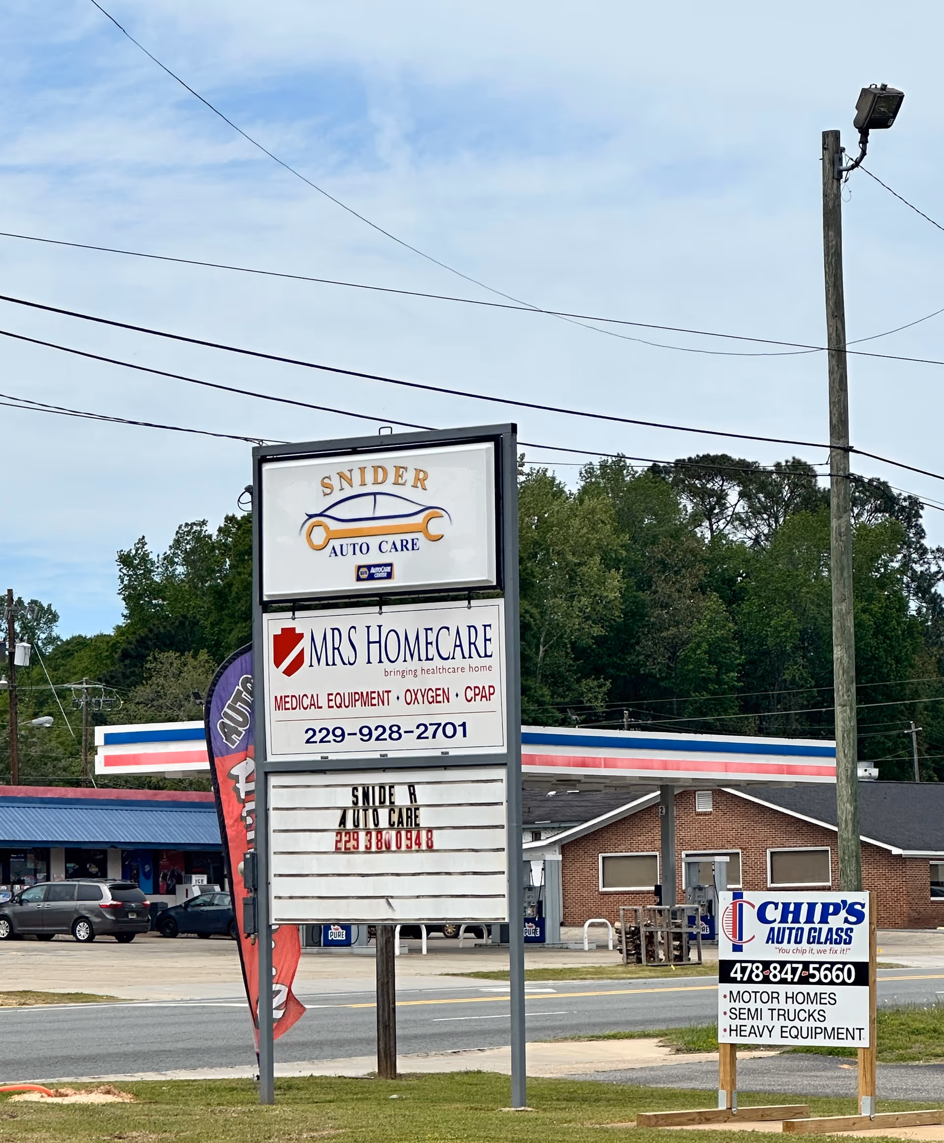 Exterior street scene with large signs for Snider Auto Care and MRS Homecare in front.