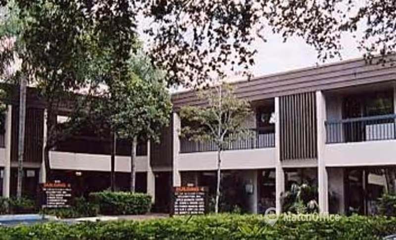 Exterior view of a two-story senior care facility with balconies and landscaped grounds.