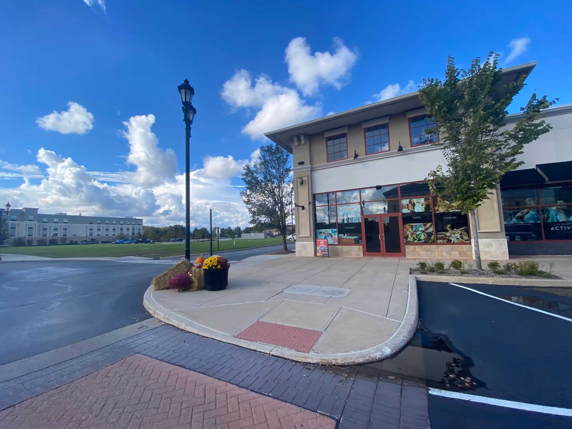Exterior view of The Commons facility with entrance, parking, and landscaping.