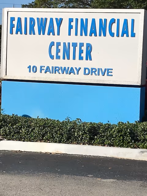 An outdoor sign reads 'Fairway Financial Center' with a blue base and hedges.