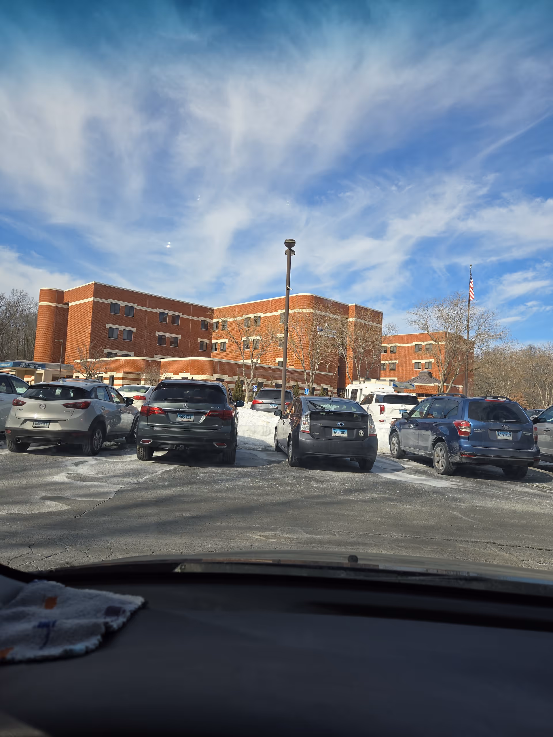 Exterior view of Hebrew Center for Health and Rehabilitation with parked cars.