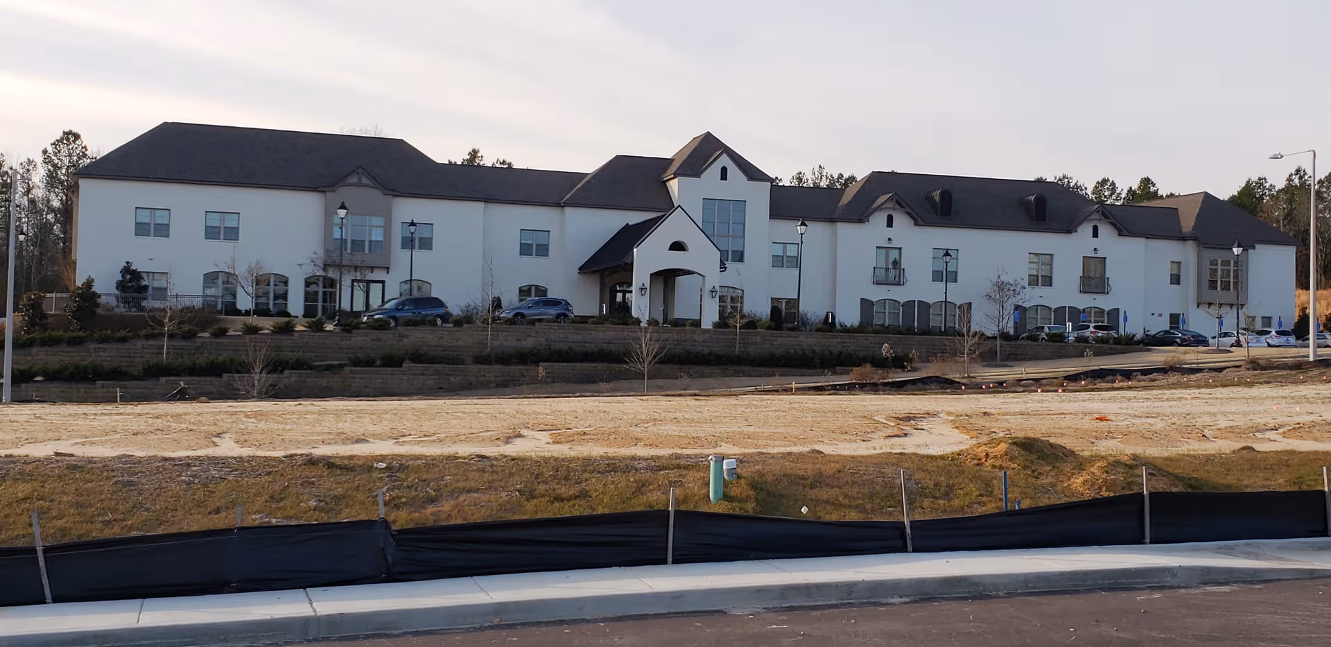 White senior living facility with curved entry and multiple wings under construction.