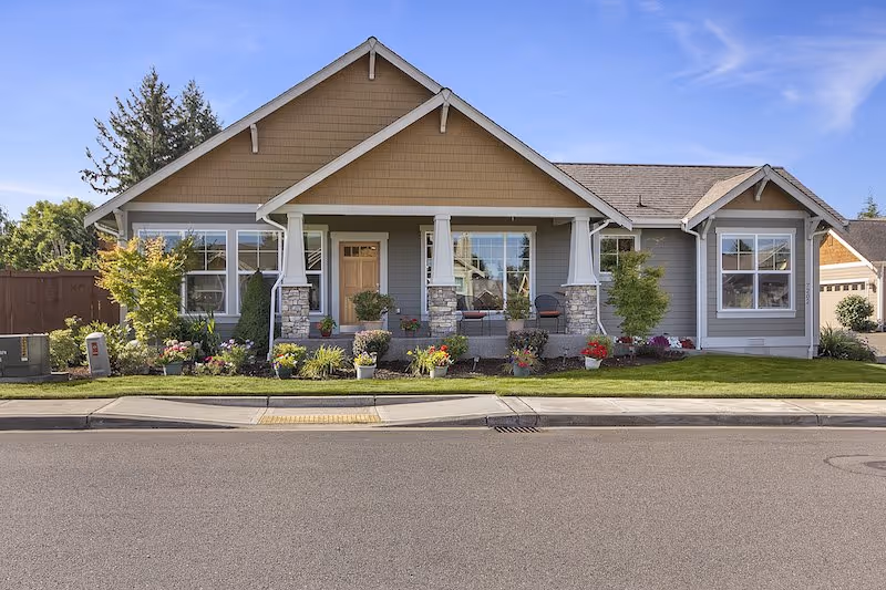 Front view of a single-story senior living facility with a landscaped yard.