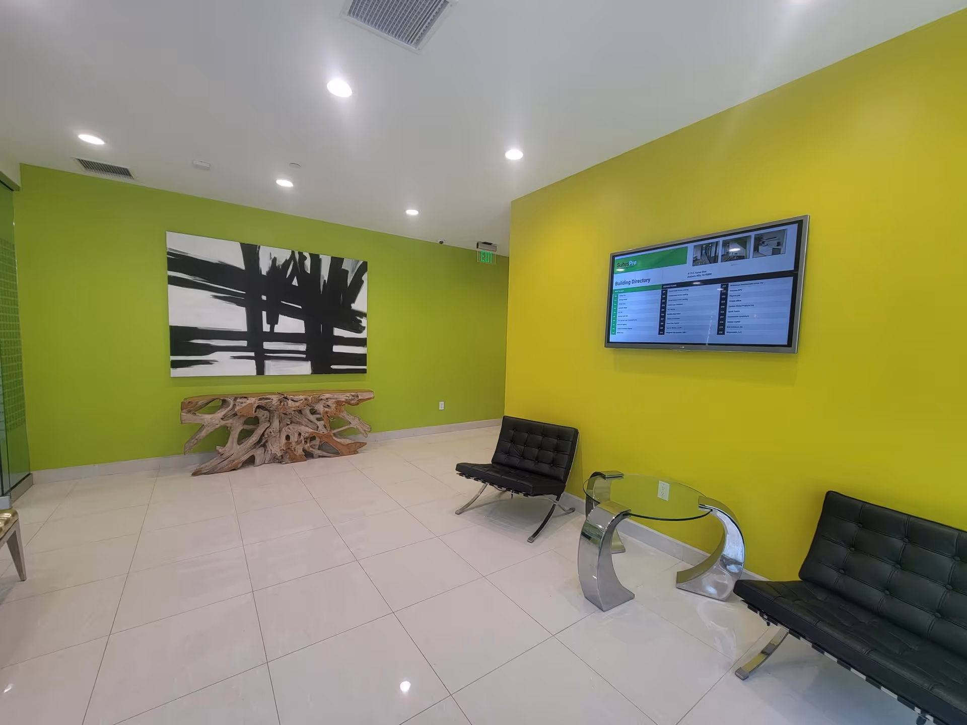 Bright lime-walled Heart to Heart Caregivers lobby with modern seating and a wall-mounted directory.