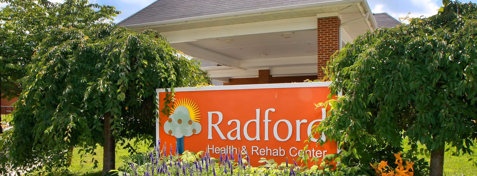 Radford Health & Rehab Center sign visible beside lush trees outdoors.