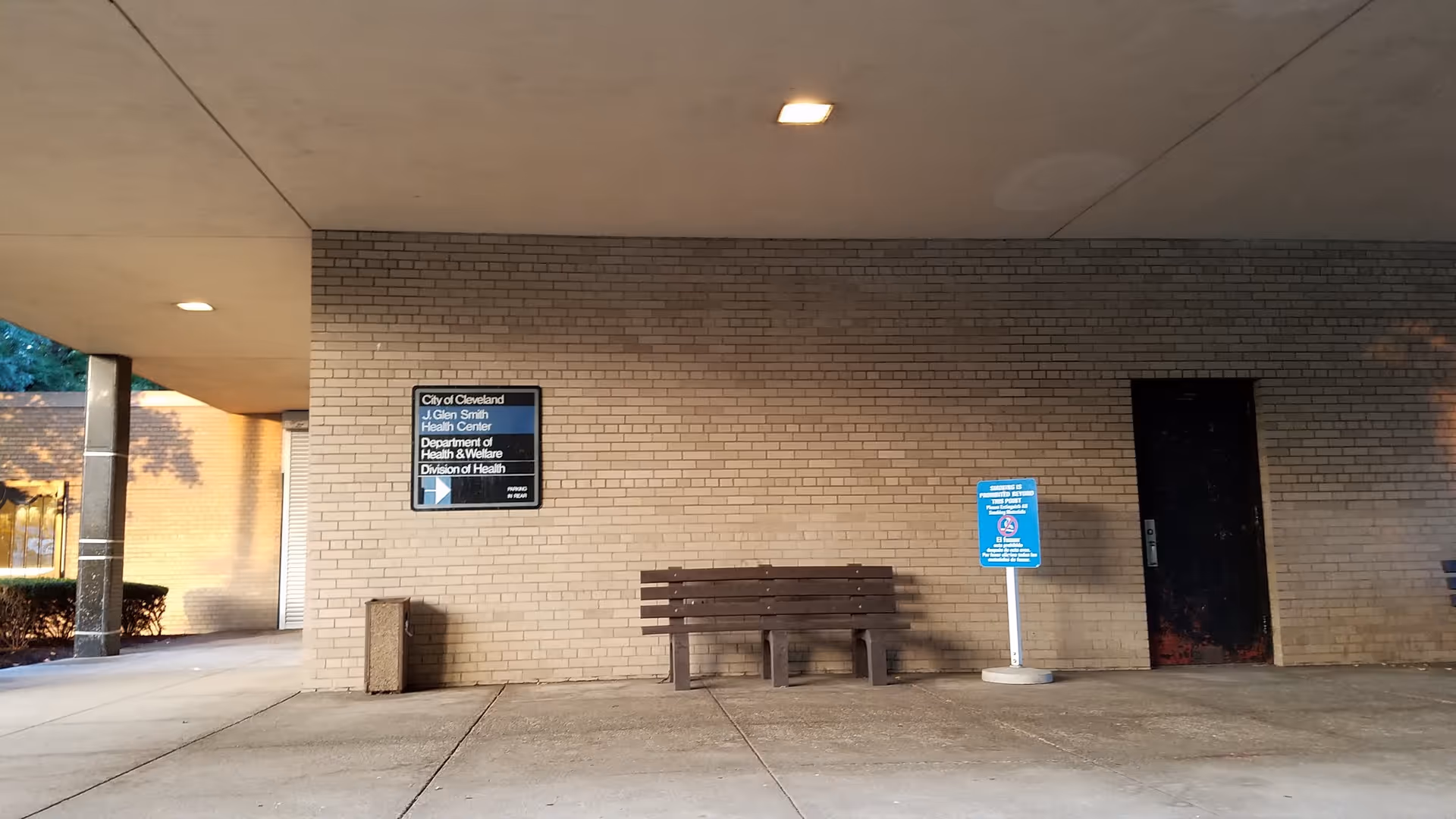 Exterior brick wall of Glenville Health Center with bench and doorway.