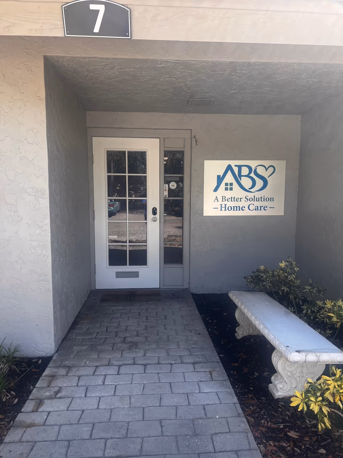 Entrance to A Better Solution Home Care facility with glass door and branded sign.