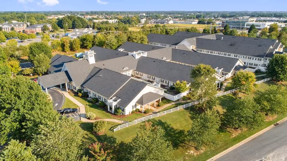 Aerial view of Terrabella Lake Norman senior living campus with connected white buildings and green grounds.