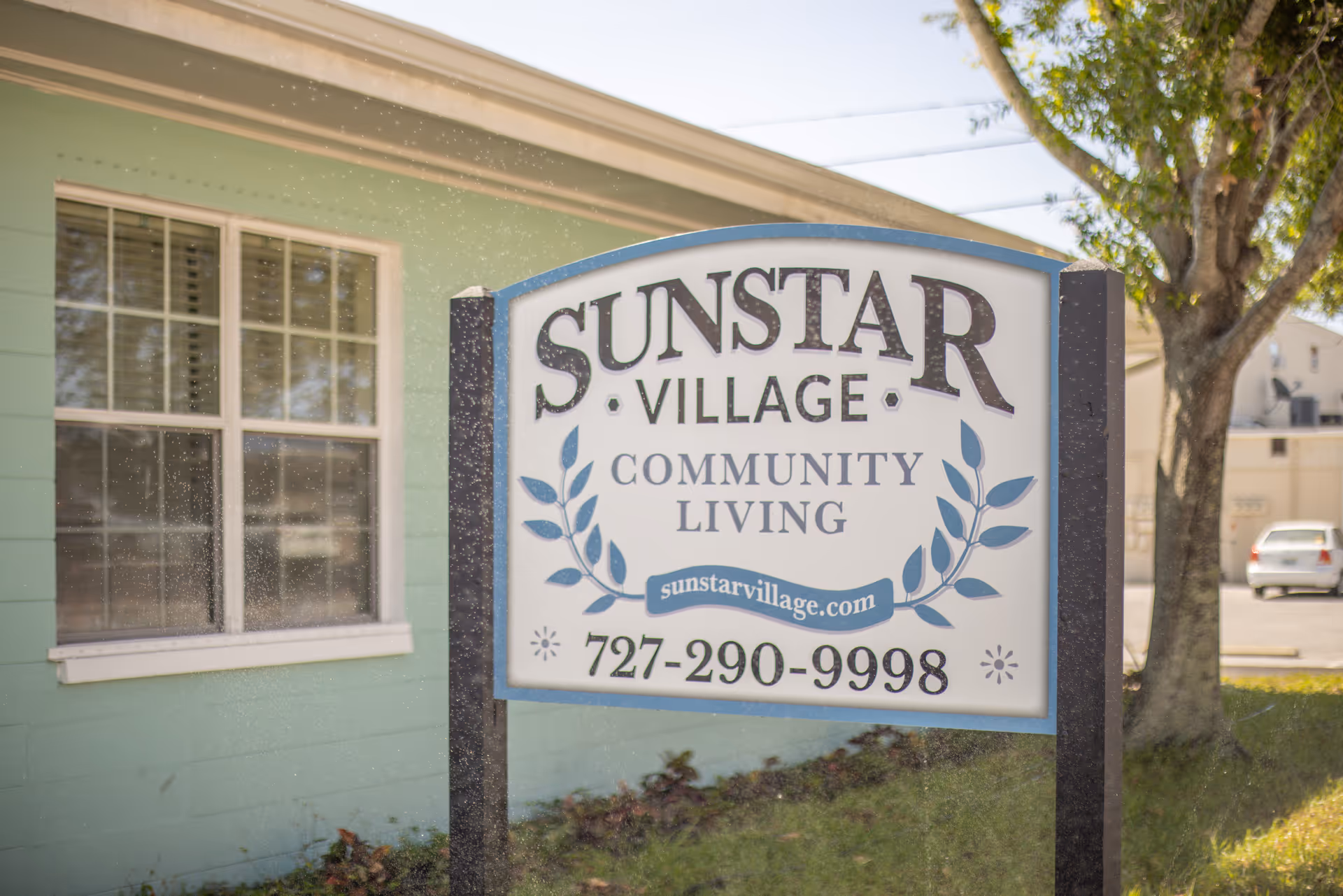 Exterior view of a teal building with a large sign reading Sunstar Village Community Living.