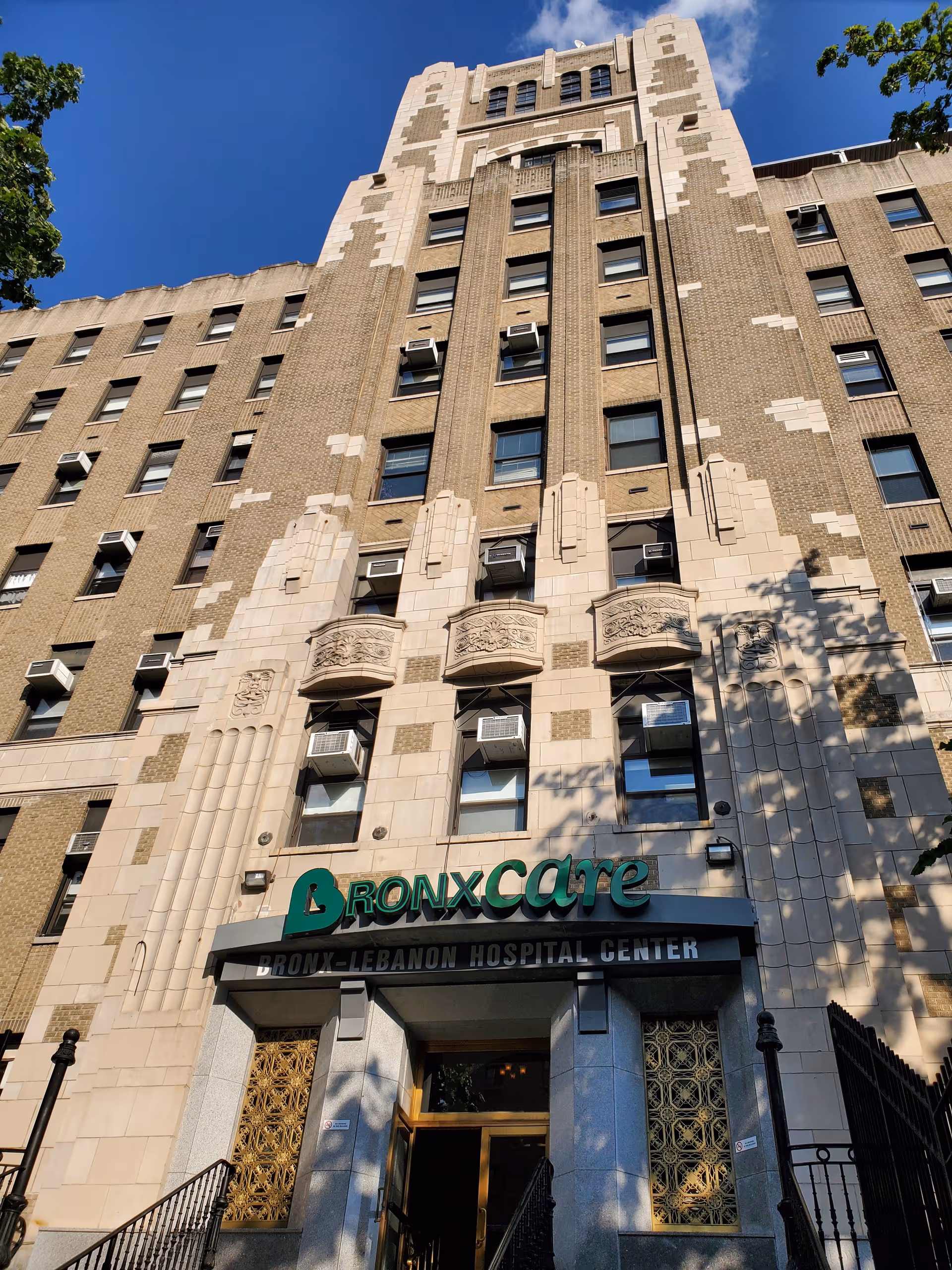 Tall brick hospital exterior with BronxCare sign and main entrance at ground level.