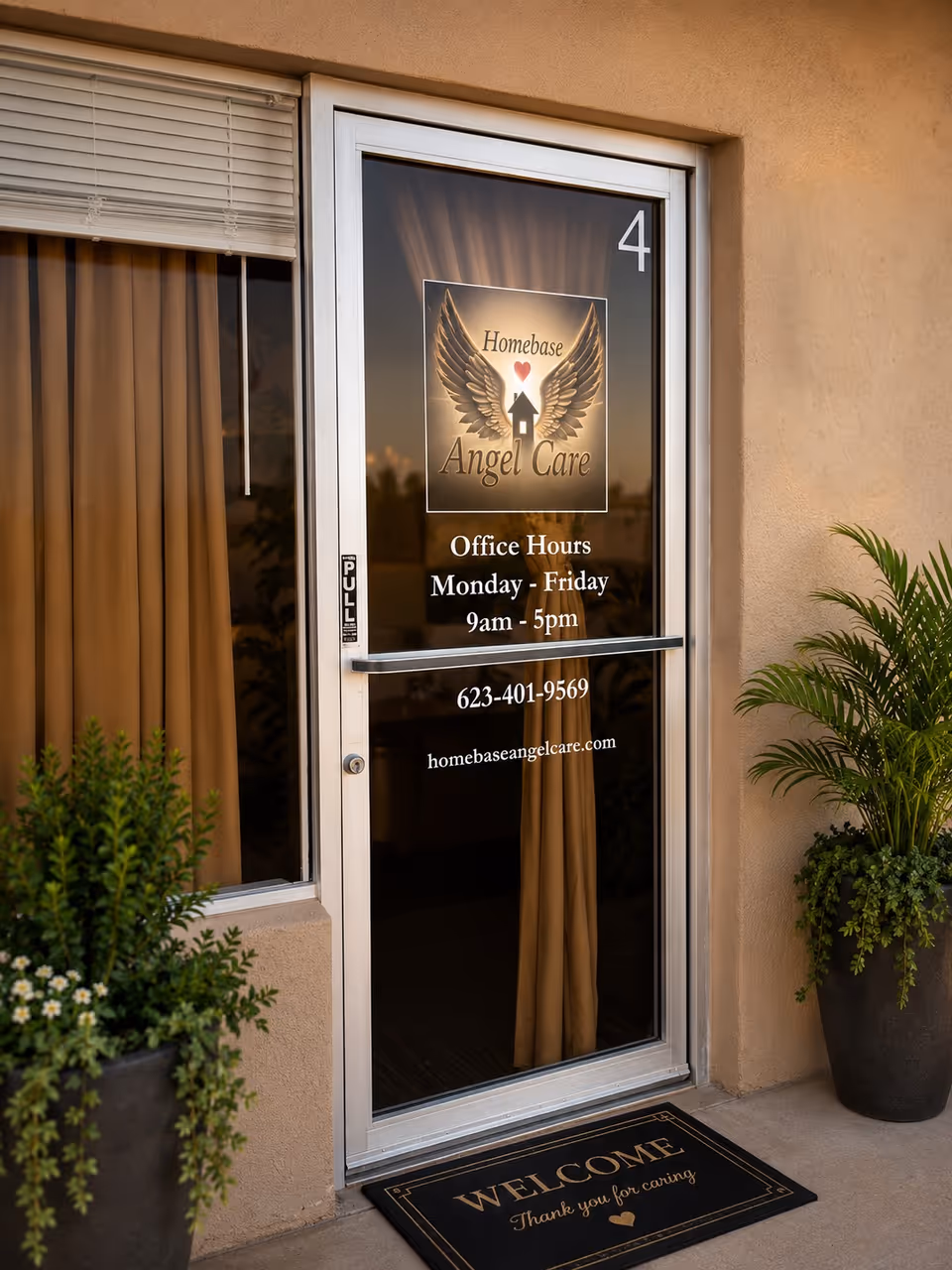 Glass door with Homebase Angel Care logo, hours, and a welcome mat outside.