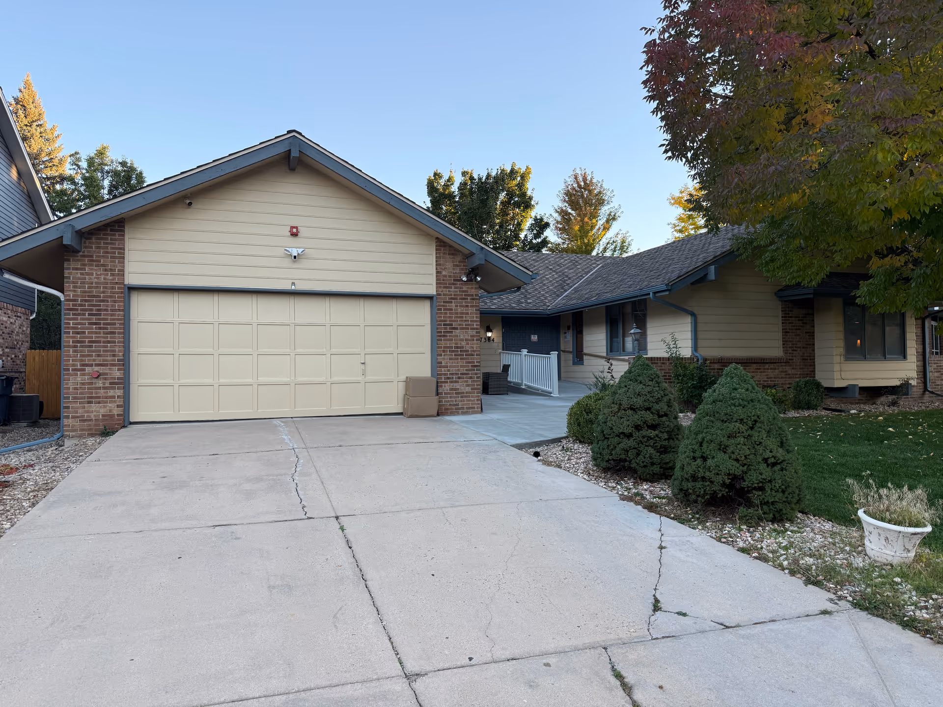 Almond Tree Senior Care building exterior with beige garage and concrete driveway.