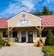 Front entrance of a beige building with red roof and Live Free Home Health Care sign.