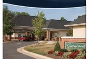 Exterior view of Plaza Health and Rehab Center entrance with drive, trees, and landscaping.