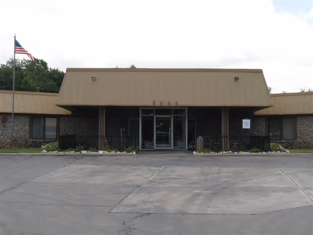 Front entrance of Emerald Care Center Southwest with flag and parking lot in view