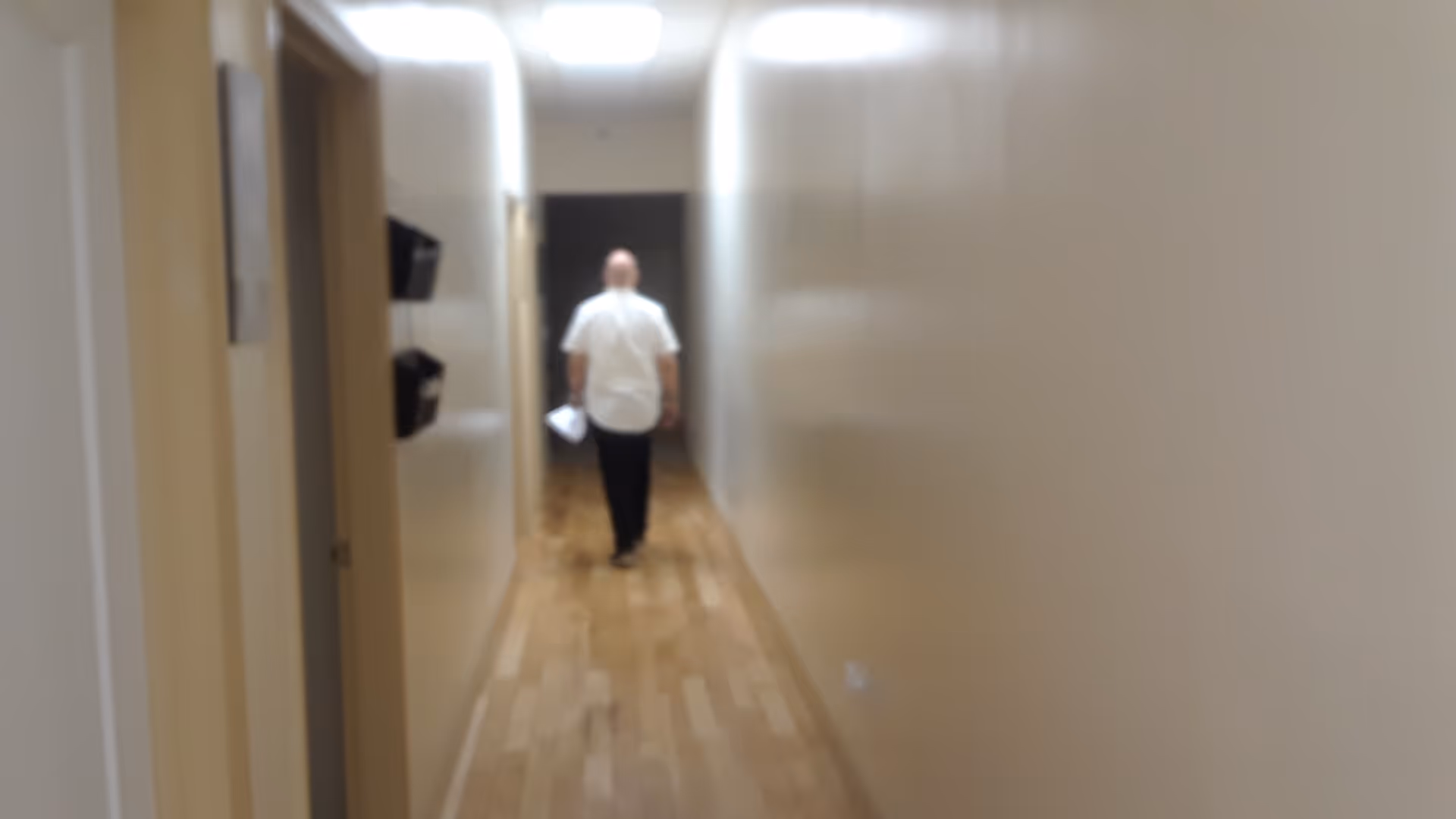 A person walks down a hallway inside a senior living facility.