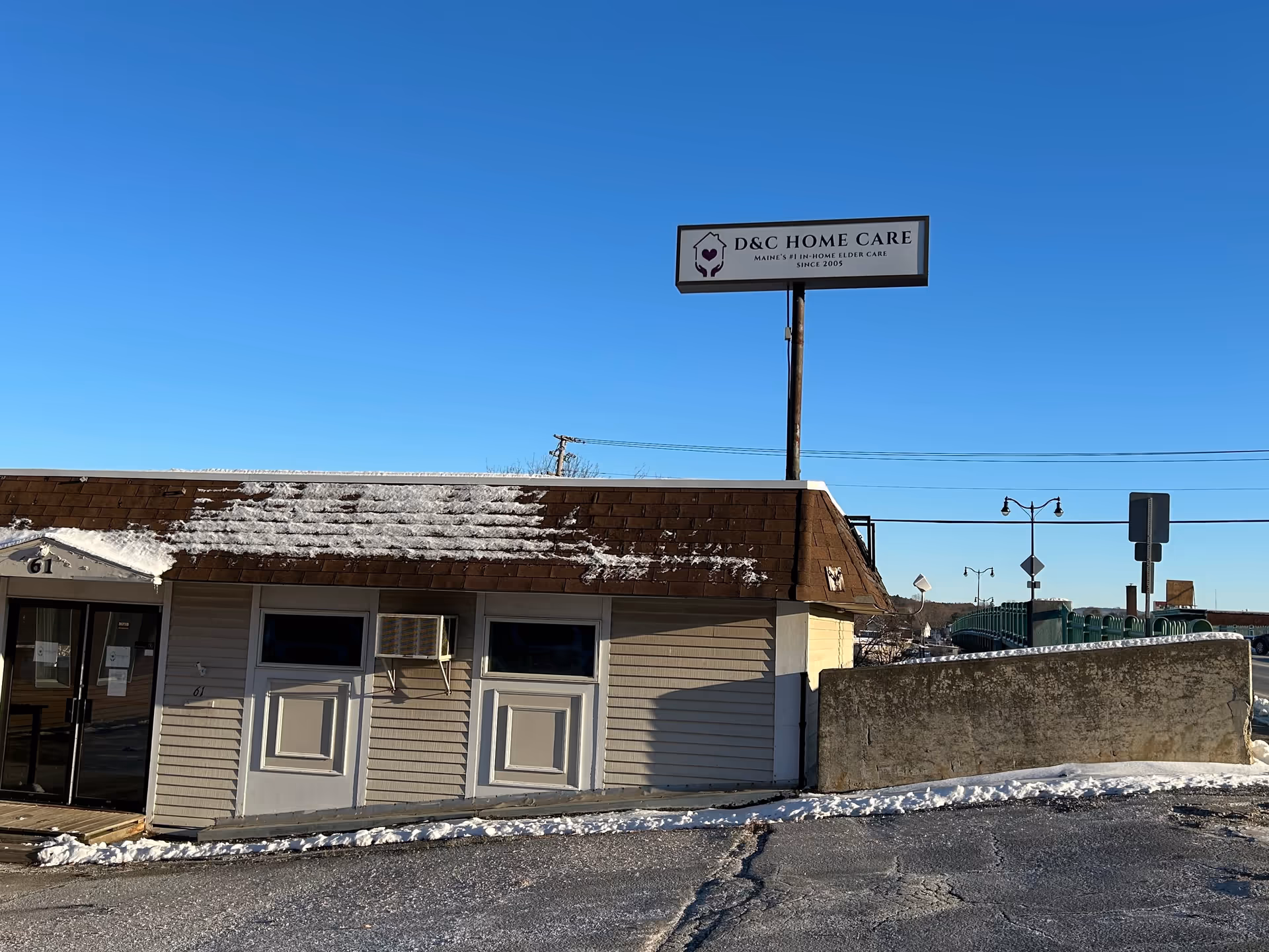 Exterior view of a single-story building with a D&C Home Care sign on a tall pole