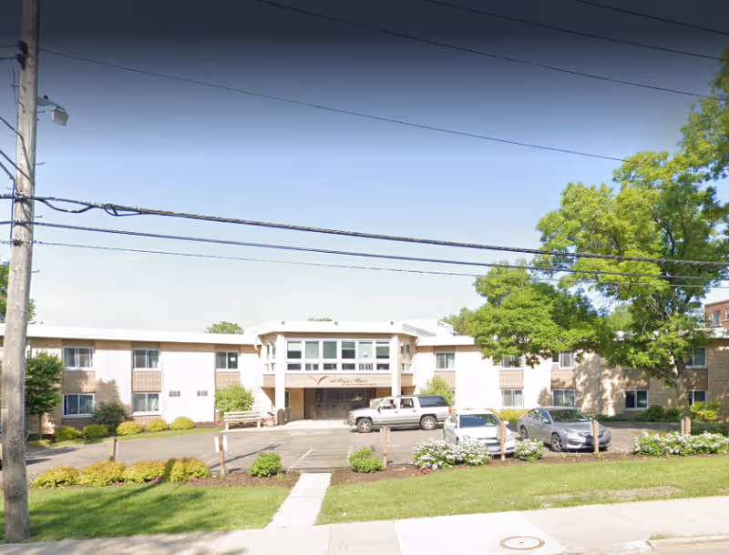 Senior living facility front exterior with parking and landscaping.