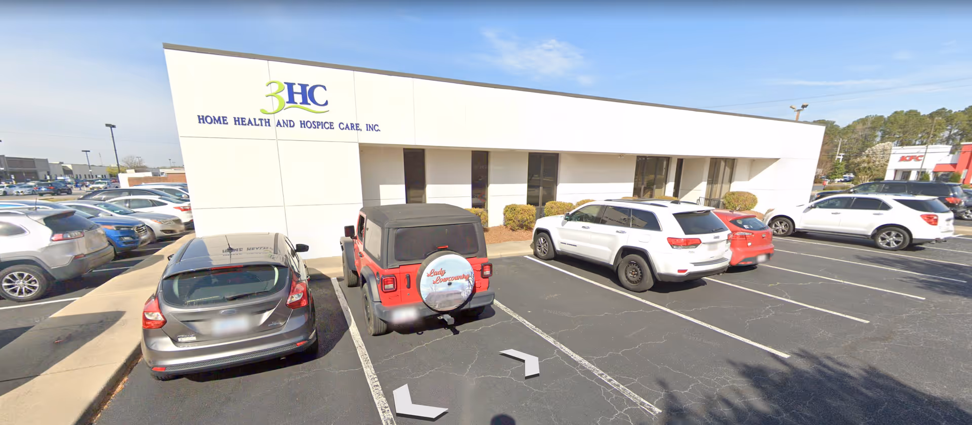 Exterior view of 3HC Home Health and Hospice Care building with parked cars.