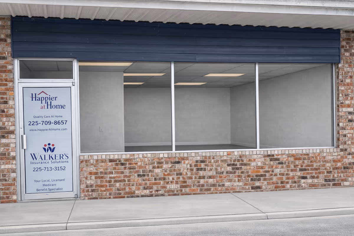 Front view of a brick building with Happier at Home sign and empty storefront windows.