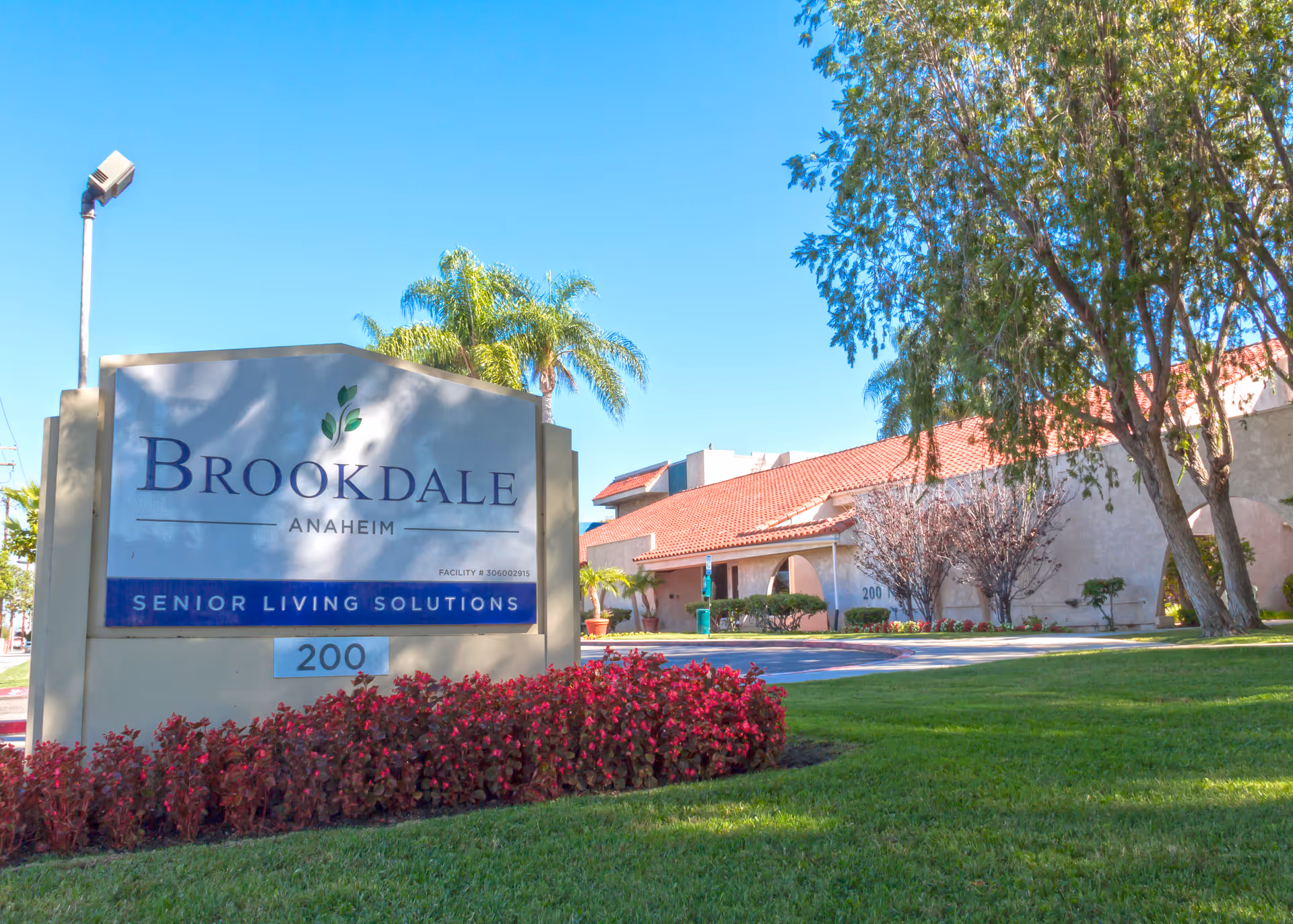Brookdale Anaheim exterior sign in front of a red-tiled building with palm trees.