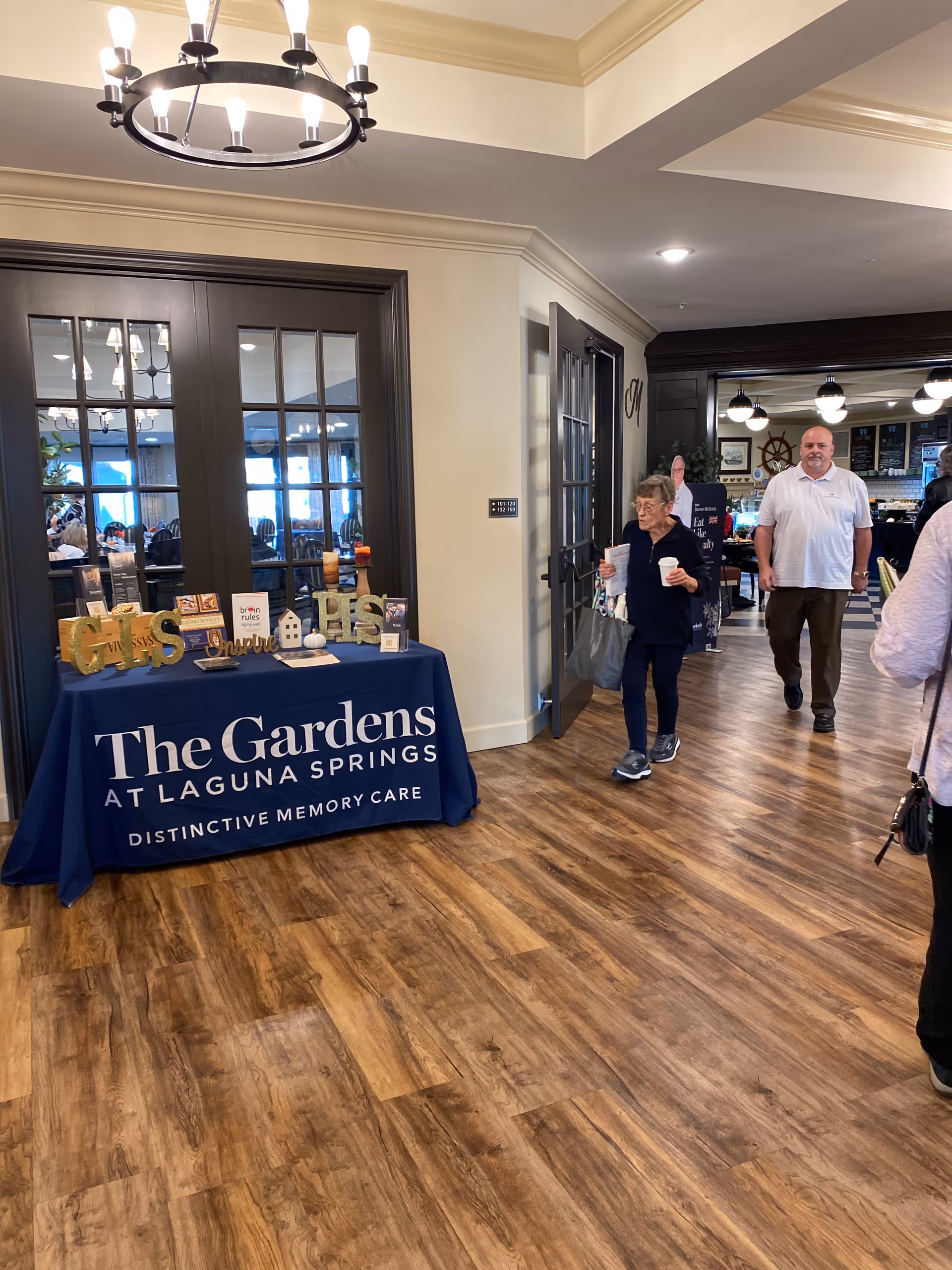 Interior lobby at Gardens at Laguna Springs with a reception table and visitors.