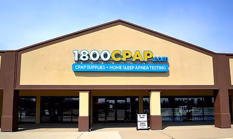 Exterior storefront with tan facade and a large 1800CPAP.com sign over glass doors.