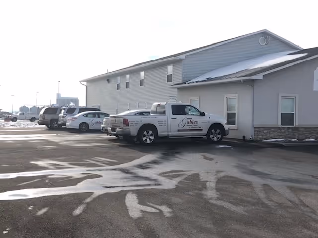 Exterior view of Gables In Home Care Services building with parked service vans.