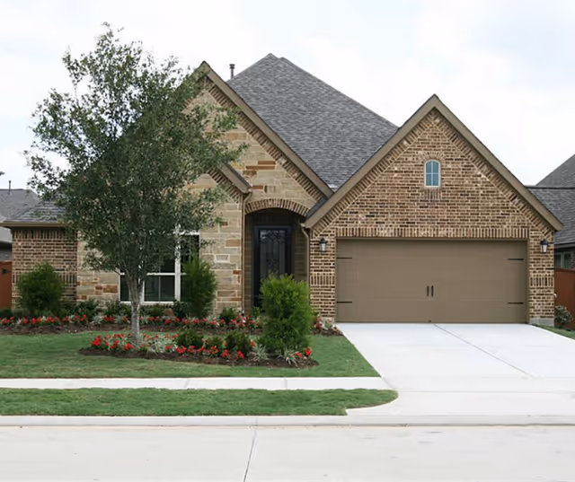 Brick exterior of a home with a two-car garage and landscaping.