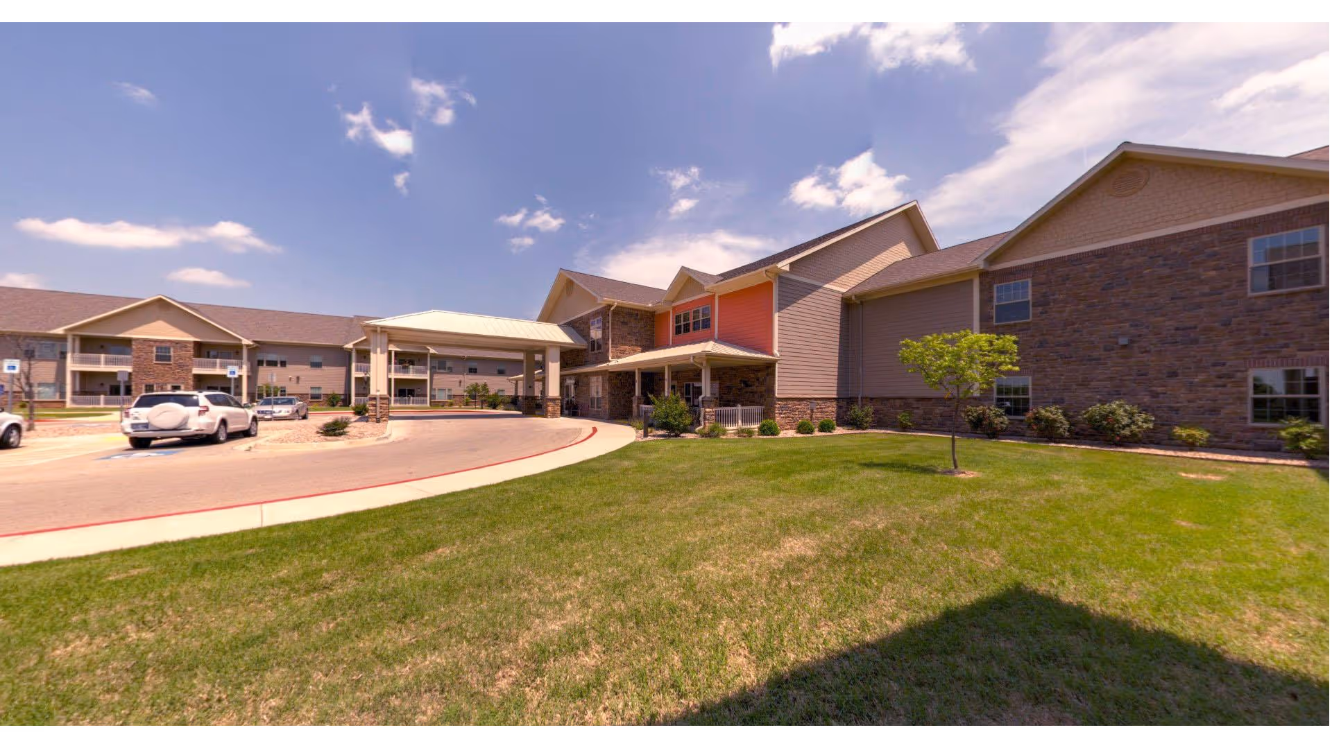 Exterior view of Stillwater Primrose facility with curved driveway and grassy front lawn