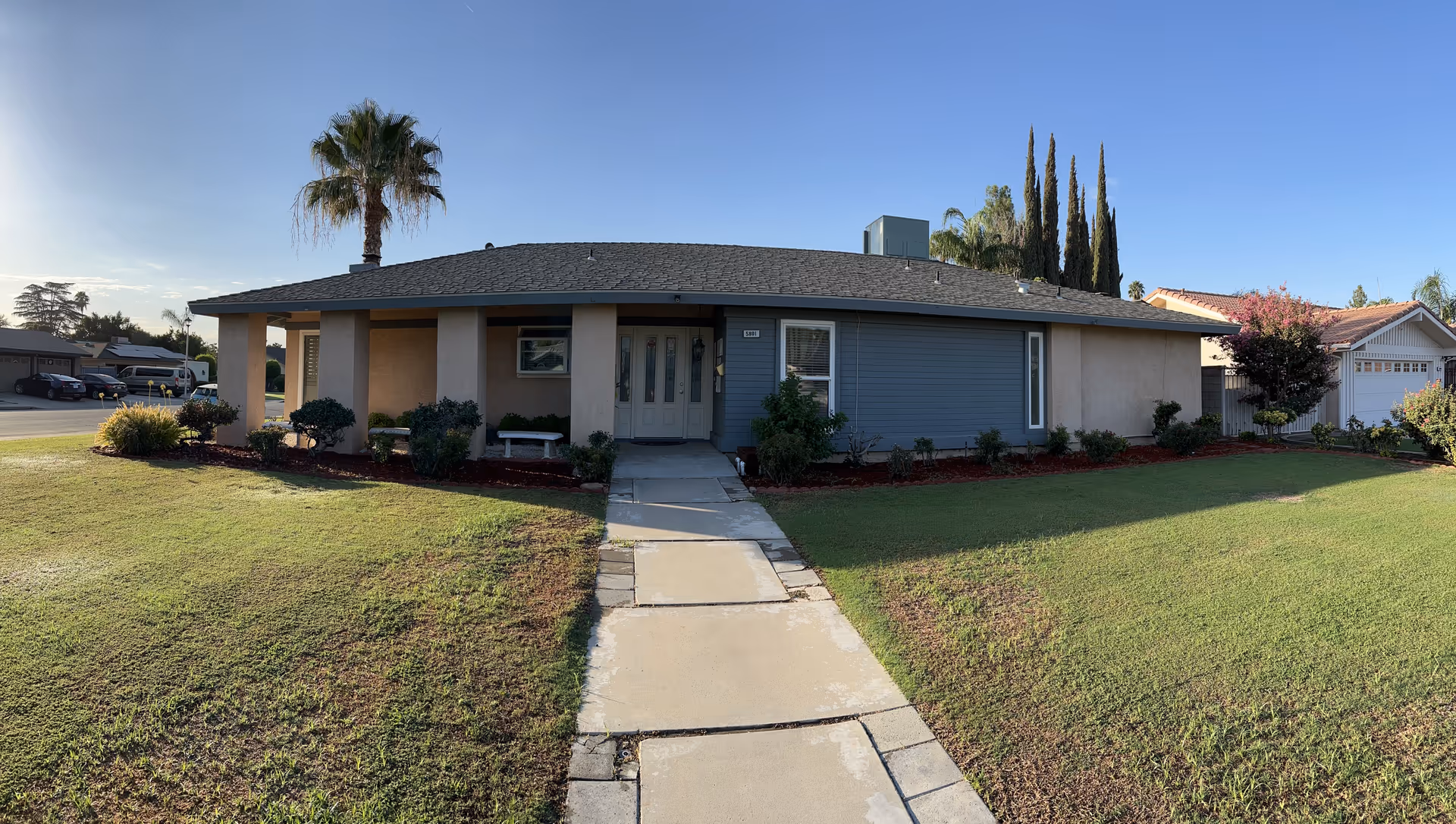 Single-story front of a senior care home with a walkway and manicured lawn.