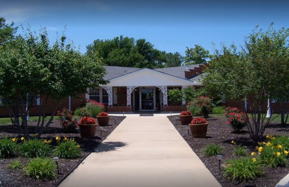 Front view of Heritage Avonlea of Olathe entrance with walkway and landscaped shrubs