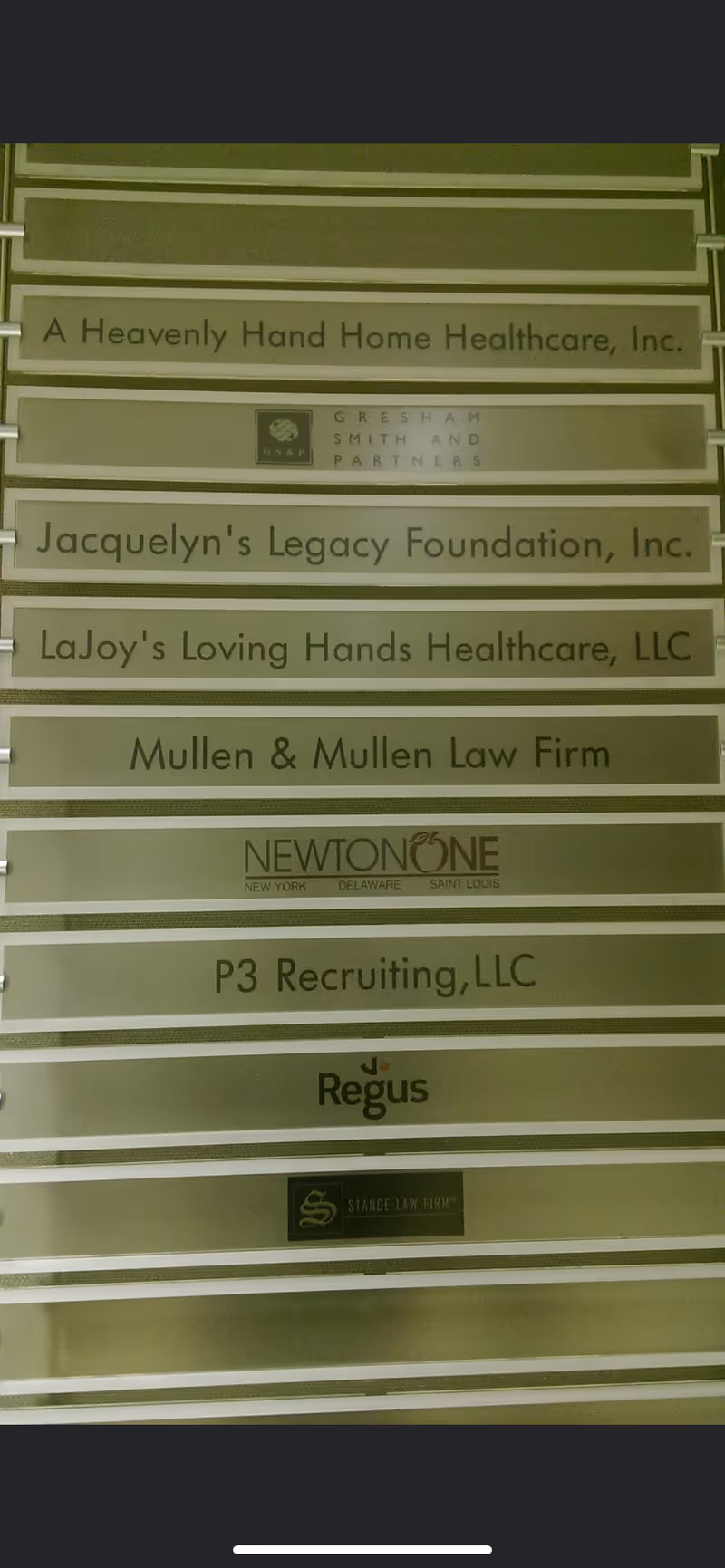 Interior wall with signboard listing various business names including A Heavenly Hand Home Healthcare, Inc.