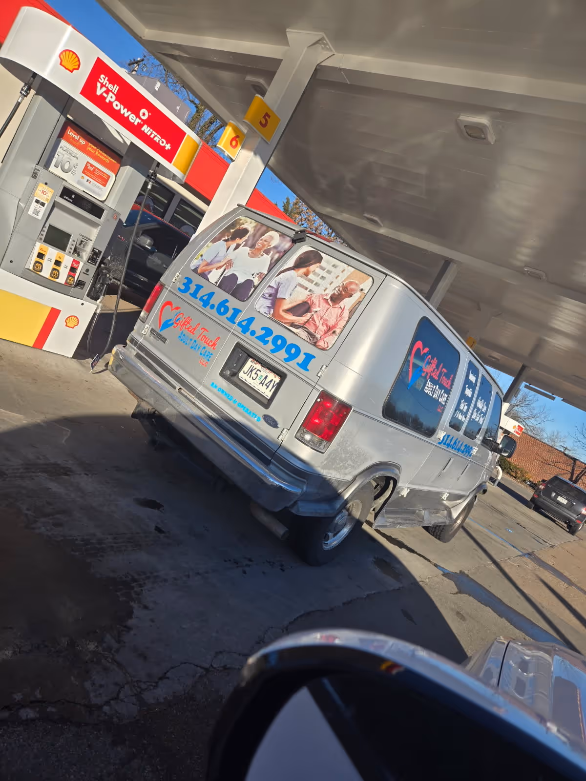 A Gifted Touch Adult Daycare van parked at a Shell gas station.