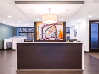 Modern reception desk in a senior living lobby with abstract art.