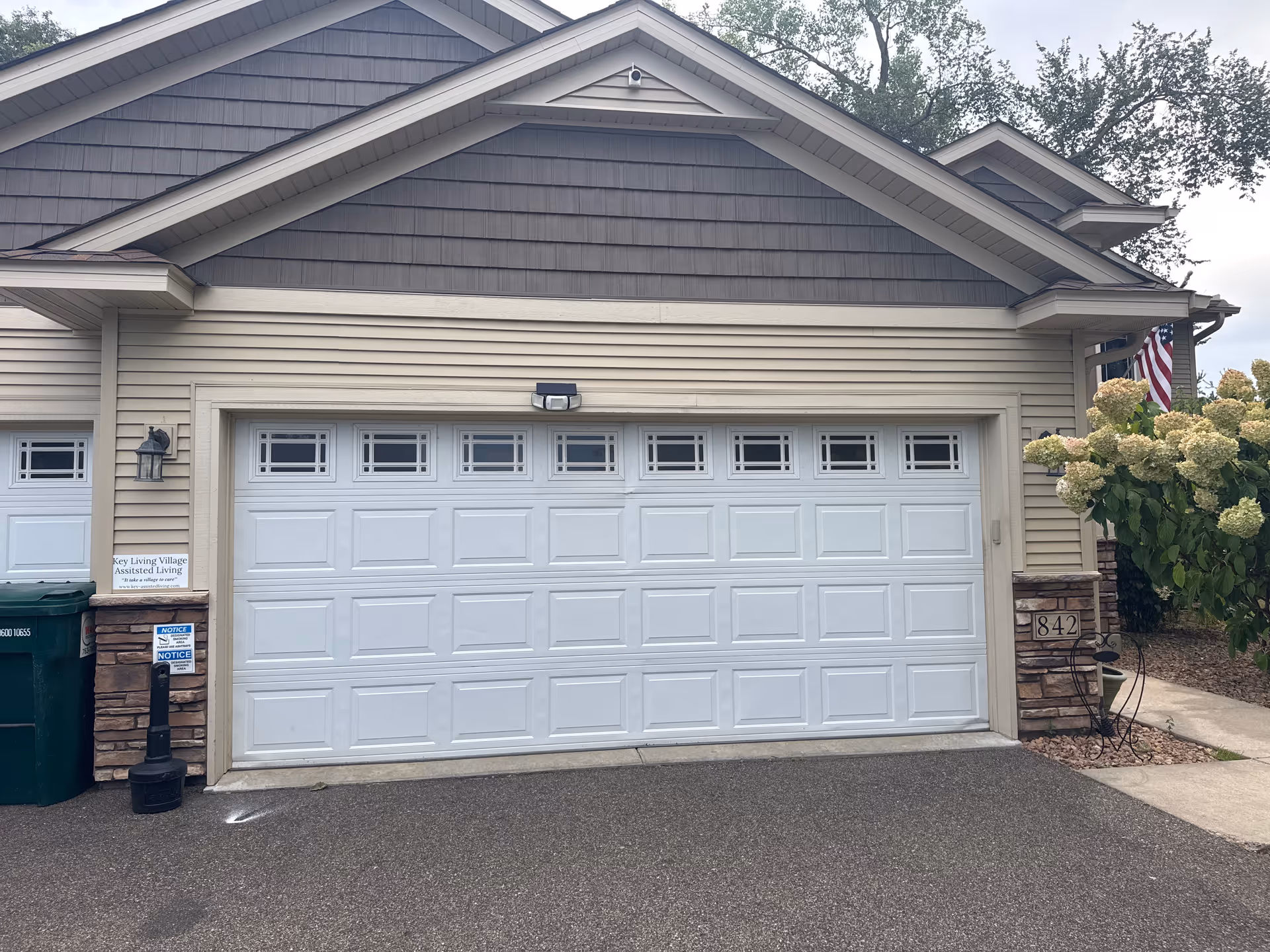 Front exterior of Key Living Village facility with a large white garage door.