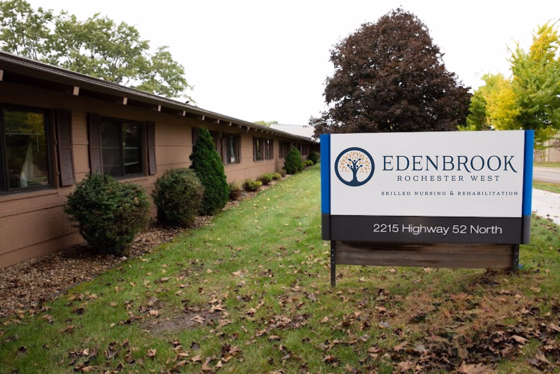 Low single-story building and lawn with a large sign reading Edenbrook Rochester West and the address 2215 Highway 52 North.
