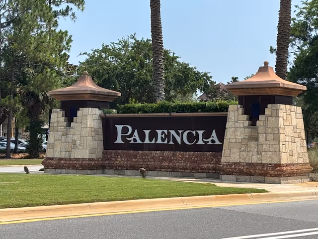 Stone entrance sign reading Palenca with two towers and palm trees